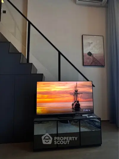 Modern living room with sleek staircase and stylish TV setup, perfect for contemporary urban living.