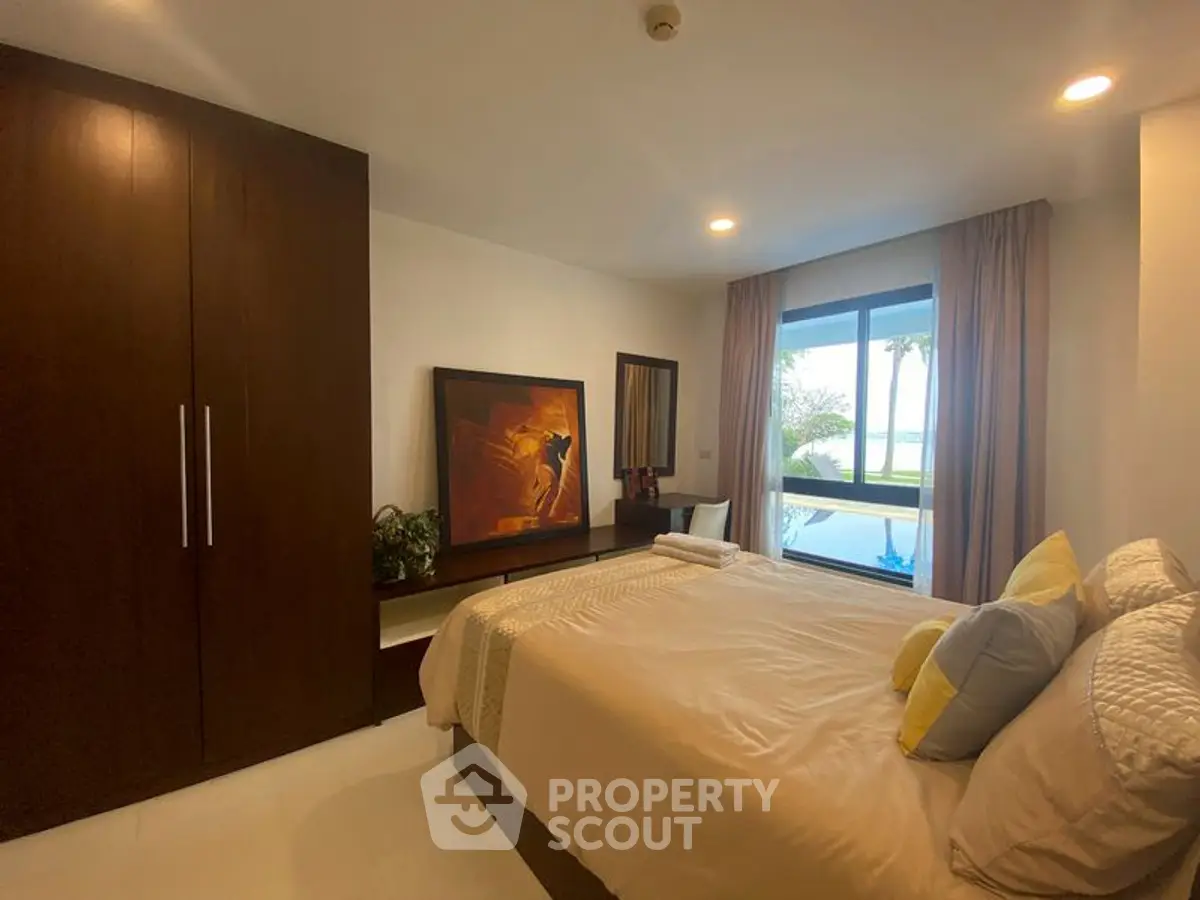 Cozy bedroom with modern decor and large window offering scenic views