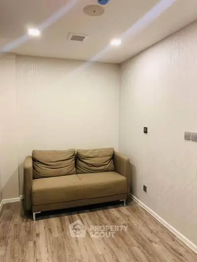 Cozy living room with a comfortable brown sofa and modern lighting, perfect for relaxation.
