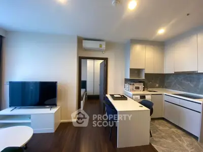 Modern open-layout living room with sleek kitchen and stylish furniture