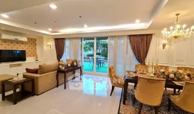Luxurious open-plan living and dining area with elegant decor and garden view.
