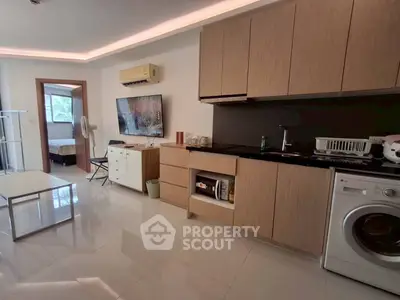 Modern open-layout kitchen with washing machine and sleek cabinetry