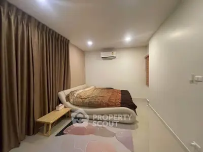 Cozy bedroom with modern bed and stylish decor in a serene setting.