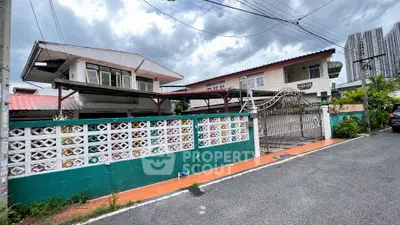 Charming suburban house with colorful fence and gated entrance, perfect for family living.