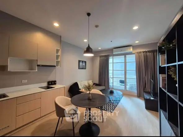 Modern living room with open kitchen, stylish decor, and balcony view in a cozy apartment.