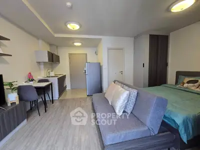 Modern studio apartment with open layout, featuring a cozy living area and compact kitchen.