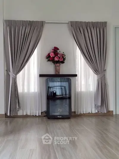 Elegant living room with stylish curtains and modern decor, featuring a sleek floor design.