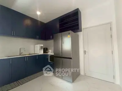 Modern kitchen with sleek blue cabinets and stainless steel appliances