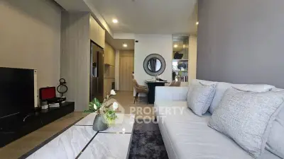 Modern living room with elegant decor and open layout, featuring a cozy sofa and stylish dining area.