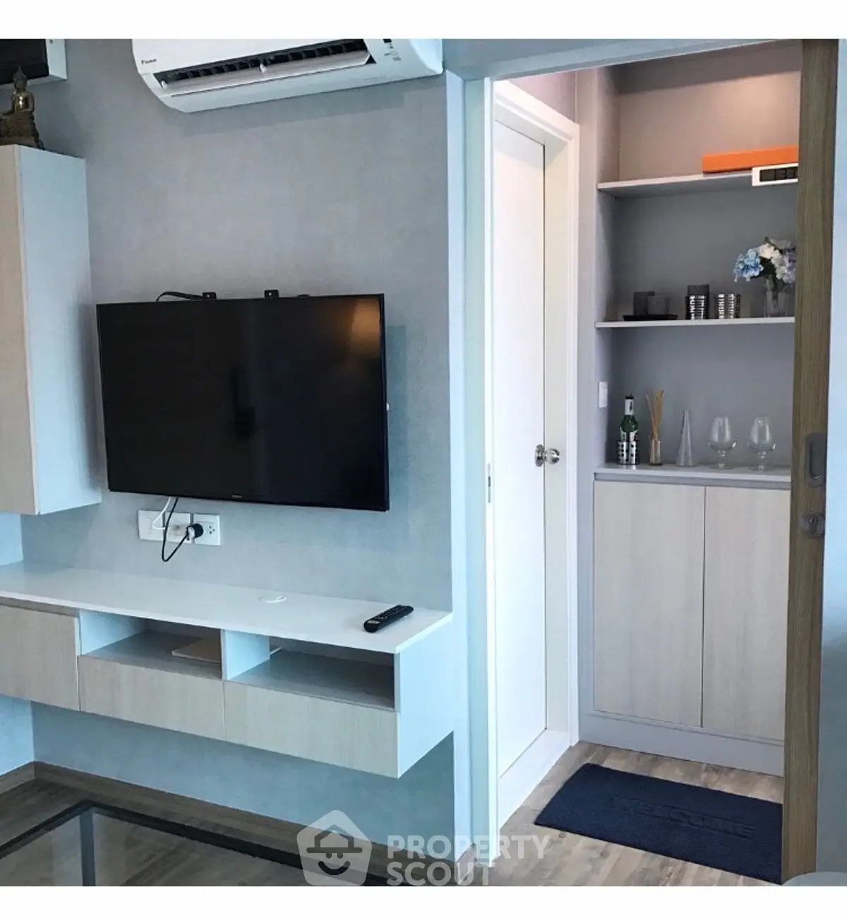 Modern living room with wall-mounted TV and sleek storage unit