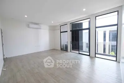 Spacious modern living room with large windows and balcony access