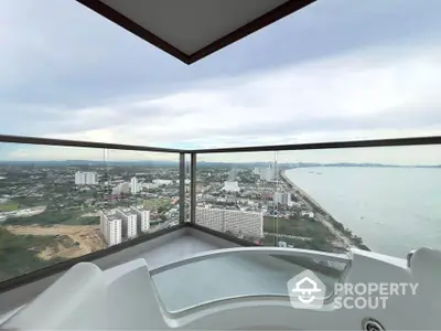 Stunning high-rise balcony with panoramic ocean and city views, perfect for relaxation and luxury living.