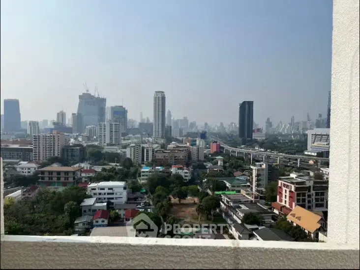 Stunning cityscape view from a high-rise balcony showcasing urban skyline and greenery.