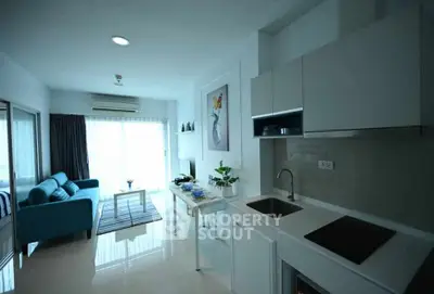 Modern open-plan living room and kitchen with sleek design and natural light.