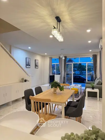 Spacious modern living room with elegant dining area and large windows for natural light.