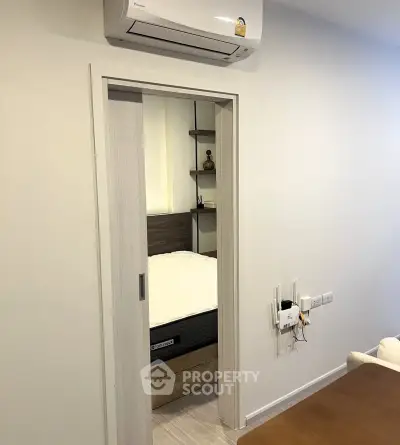 Cozy bedroom entrance with sliding door and air conditioning unit, perfect for modern living.