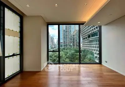 Spacious modern living room with floor-to-ceiling windows and city view.