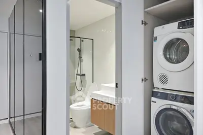 Modern bathroom with glass shower and in-unit laundry appliances