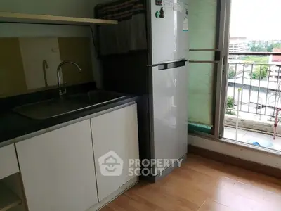 Modern kitchen with sleek cabinets and balcony view, perfect for urban living.