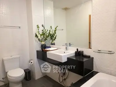 Modern bathroom with sleek fixtures and elegant decor, featuring a spacious vanity and bathtub.