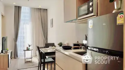 Modern open-plan kitchen and living area with natural light and sleek appliances.