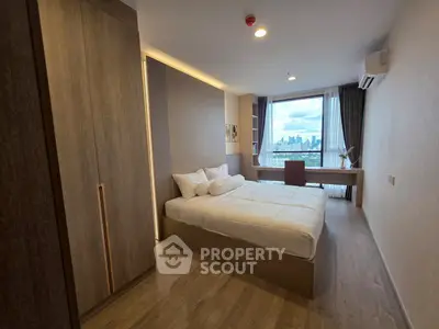 Modern bedroom with city view, featuring sleek design and ample natural light.