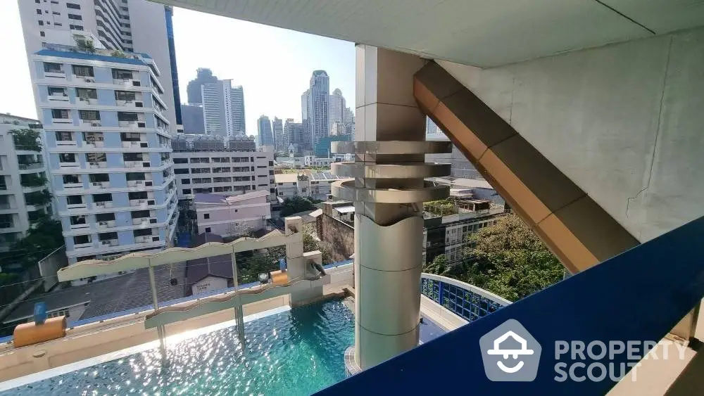 Luxurious high-rise condo balcony with a stunning cityscape and pool view, perfect for urban living and relaxation in a prime location.