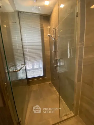 Luxurious modern bathroom with glass shower enclosure and elegant tile design.