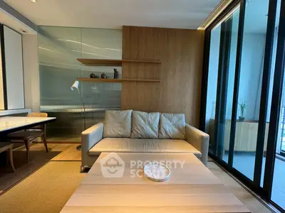 Modern living room with sleek design, featuring a cozy sofa, wooden accents, and large glass doors leading to a balcony.