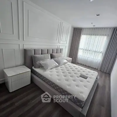 Modern bedroom with elegant decor and large window for natural light.