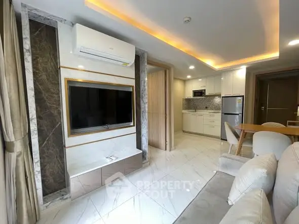 Modern living room with open kitchen, featuring sleek design and elegant lighting.