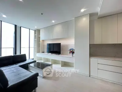 Modern living room with sleek black sofa and built-in TV unit