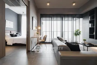 Modern open-plan living room with sleek design and natural light, featuring a cozy bedroom view.