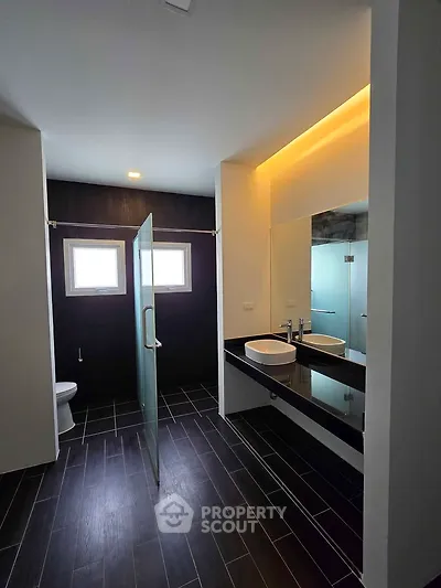 Modern bathroom with dual sinks and glass shower enclosure