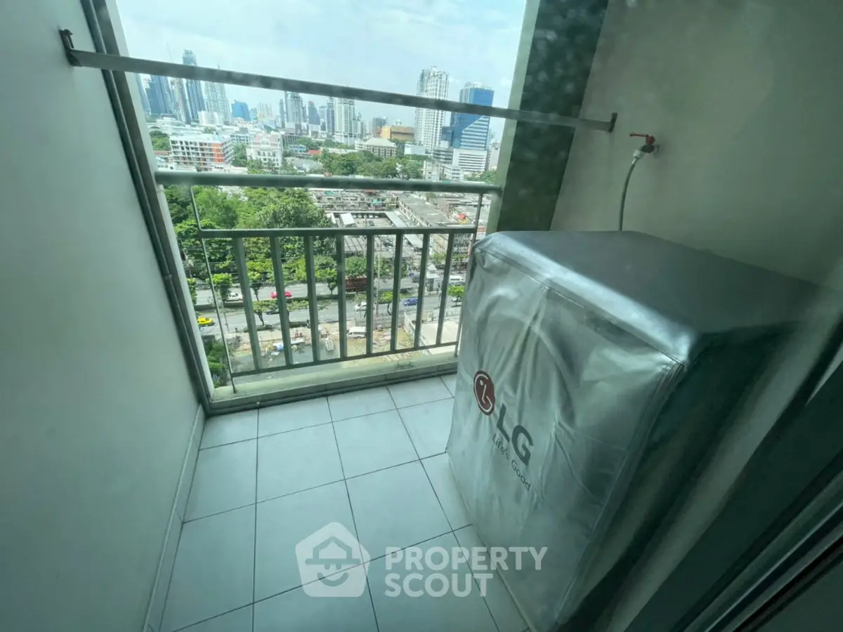 High-rise balcony with city view and covered appliance, ideal for urban living.