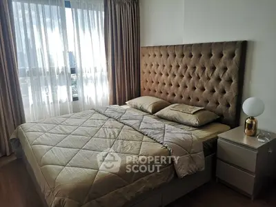 Luxurious bedroom with plush headboard and city view, perfect for relaxation and comfort.
