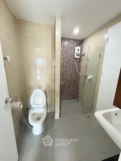 Modern bathroom with glass shower and sleek fixtures in a contemporary apartment.