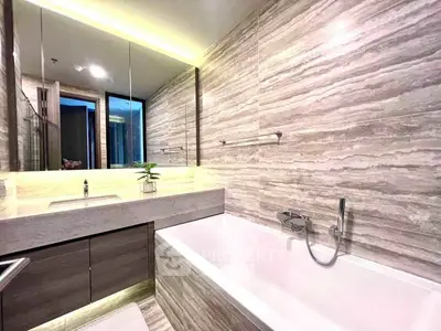 Luxurious modern bathroom with elegant marble tiles and sleek bathtub design.