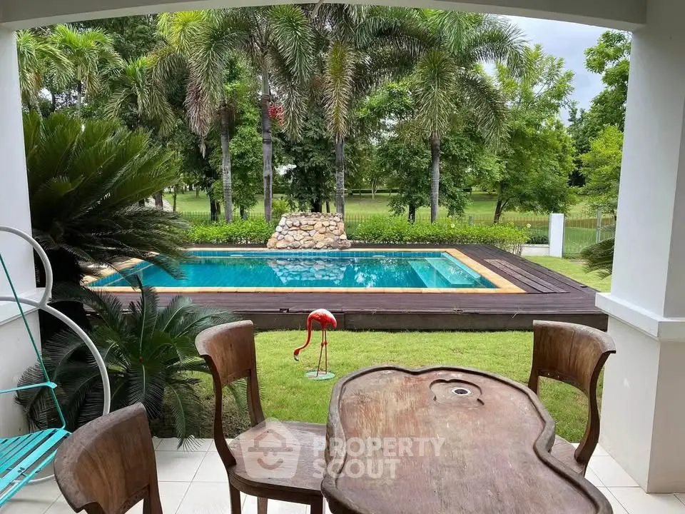 Charming patio view of lush garden and inviting pool, perfect for relaxation and outdoor enjoyment.