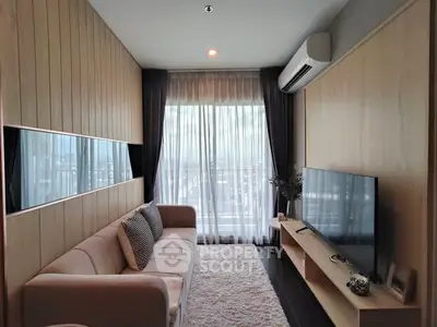 Modern living room with large window, cozy sofa, and sleek TV setup.