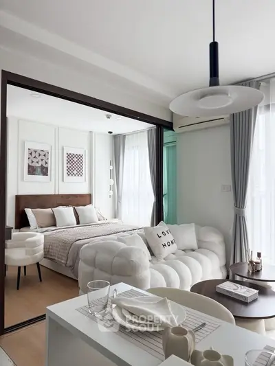 Modern open-plan living room and bedroom with stylish decor and natural light