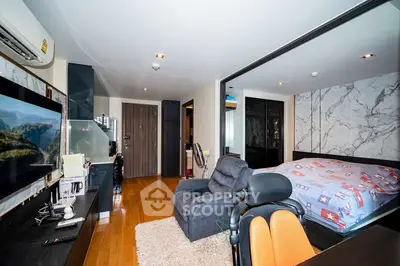 Modern bedroom with cozy seating and stylish decor in a contemporary apartment.