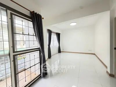 Spacious empty living room with large windows and elegant curtains in modern apartment.