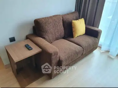 Cozy living room with brown sofa and side table, perfect for relaxation.