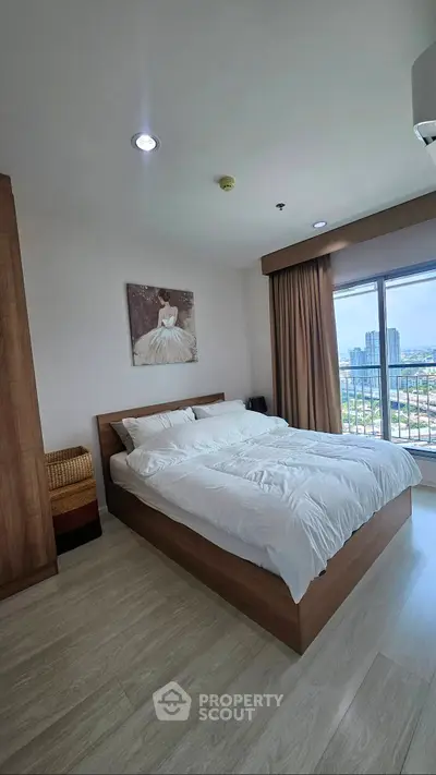 Spacious bedroom with city view, featuring a large bed and elegant decor, perfect for urban living.