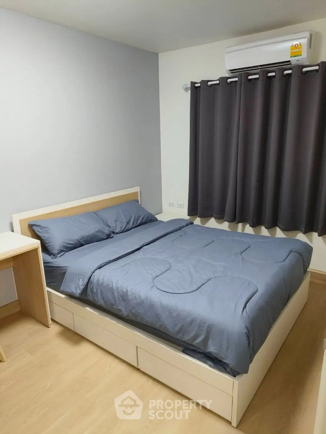 Cozy bedroom with modern furnishings and air conditioning, perfect for comfort and relaxation.