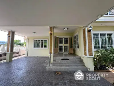 Spacious covered entrance with elegant steps and secure windows in a modern home.