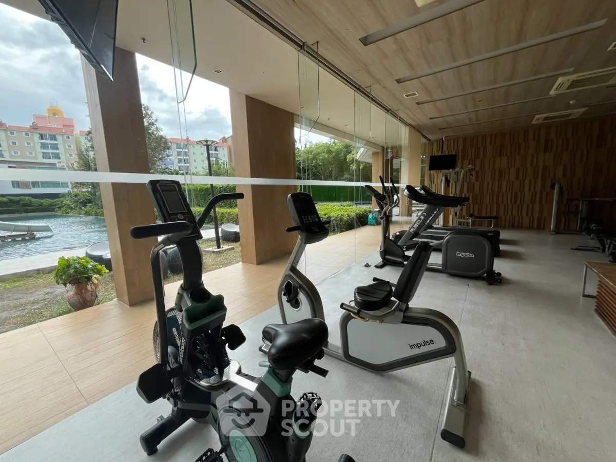Modern gym with exercise bikes and large windows overlooking a scenic view, perfect for fitness enthusiasts.