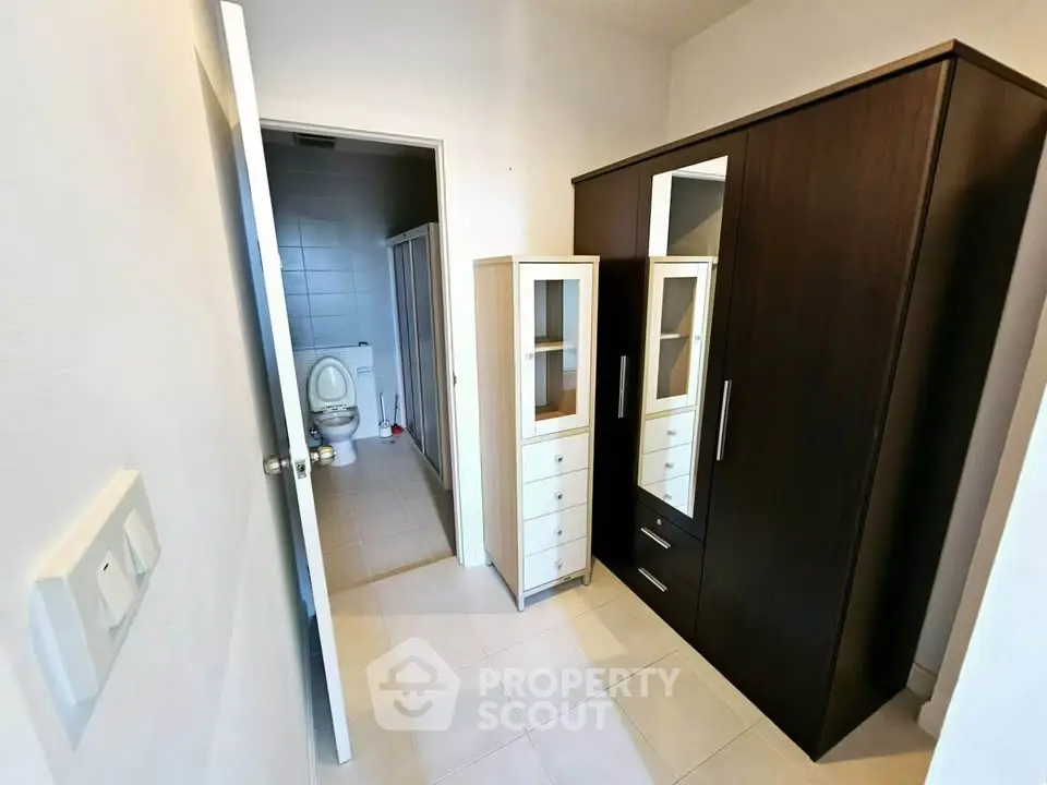 Compact hallway with wardrobe leading to a modern bathroom