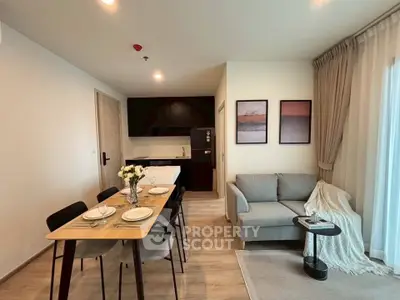 Modern open-plan living room with dining area and cozy sofa in stylish apartment.